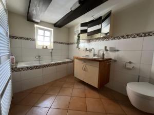ein Badezimmer mit einem Waschbecken, einer Badewanne und einem WC in der Unterkunft Urig, gemütliches Fachwerkhaus in Korbach