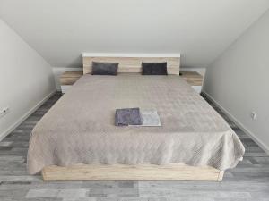 - une chambre avec un grand lit et une tête de lit en bois dans l'établissement Apartment Weikersheim II, à Weikersheim
