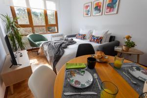 una habitación con una cama y una mesa con platos. en Apartamento Balcón de Liérganes en Liérganes