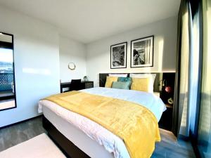 a bedroom with a large bed with a yellow blanket at GLAD Spot: Zurich - Central - Design - Netflix in Zürich