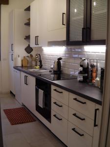 a kitchen with white cabinets and a black stove top oven at Appartamento ARCOBALENO in Tirano