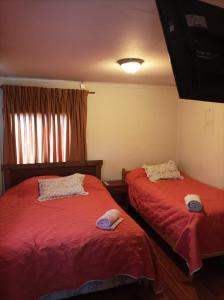 1 dormitorio con 2 camas con sombreros en Hospedaje Santa Maria y POP, en Osorno