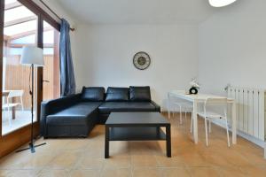sala de estar con sofá negro y mesa en Confortable appartment near Stade de France, en Saint-Denis