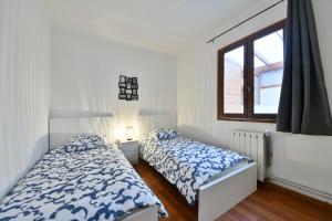 1 dormitorio con 2 camas y ventana en Confortable appartment near Stade de France, en Saint-Denis