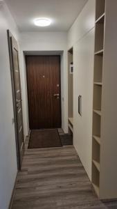 un pasillo con puerta de madera y un pasillo con estanterías en Barona apartement en Jelgava