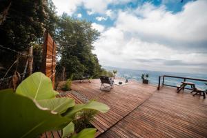 a wooden deck with a table and chairs on it at El Refugio in Quindío