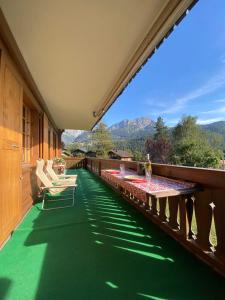 代堡Charming apartment with great view的阳台设有绿色地板和桌椅。
