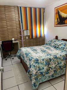 a bedroom with a bed with a colorful comforter at EDIFÍCIO METROPOLE ONDINA in Salvador