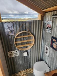 a bathroom with a toilet and a shower curtain at Two Little Piggies Glamping 