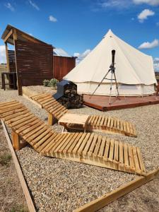 a yurt with a wooden bench and a tent at Two Little Piggies Glamping 