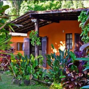une maison orange avec des plantes devant elle dans l'établissement Chales Internacional, à Parati