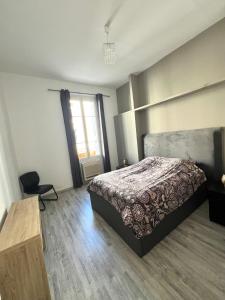 a bedroom with a bed and a table and a window at Le Théâtro in Orange +19 photos