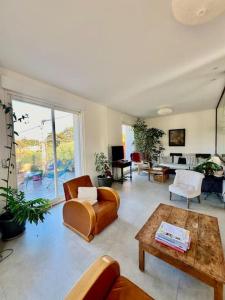 ein Wohnzimmer mit einem Sofa und einem Tisch in der Unterkunft Villa Lilou*50m de la plage in Le Pradet