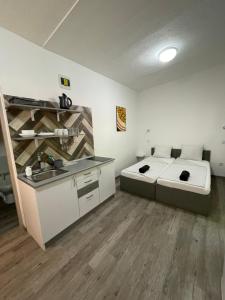 a room with a bed and a sink in it at Tutti Apartman in Balatonlelle
