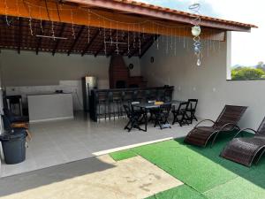 eine Terrasse mit einem Tisch und Stühlen sowie eine Küche in der Unterkunft Chacara em Socorro- SP próx ao centro, com piscina e area gourmet in Socorro