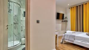 a bathroom with a bed and a glass shower at Kornata Country House in Kornáta +42 photos