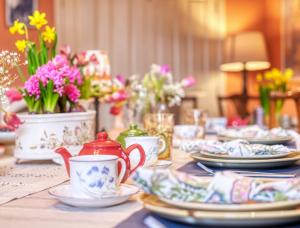 バースにあるHill Houseの皿、カップ、花が並ぶテーブル