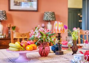 a table with fruits and vegetables on a table at Hill House in Bath