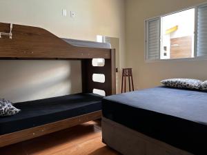 a bedroom with two bunk beds and a window at Casa de campo próx ao centro com piscina e area gourmet in Socorro