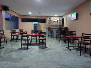 a dining room with tables and chairs and a screen at Le Grande Haven in Lunga-Lunga