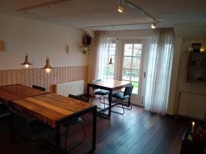 a dining room with a table and chairs and a window at De Stormvogel in Baaiduinen