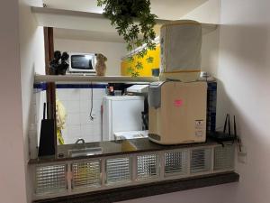 a kitchen with a counter top with a microwave at EDIFÍCIO METROPOLE ONDINA in Salvador +24 photos