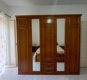einem Holzschrank mit Glastüren in einem Schlafzimmer in der Unterkunft La Dimora di Ketty in Scicli