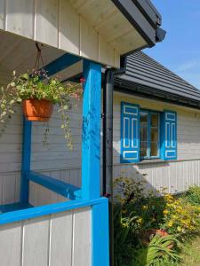 una casa con una puerta azul y una maceta en Gościniec Pod Dębami I, 