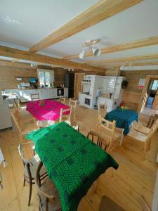 ein Wohnzimmer mit Tischen und Stühlen sowie eine Küche in der Unterkunft Gościniec Pod Dębami I 