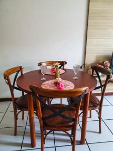 einem Holztisch mit zwei Stühlen und einem Tisch mit Brille darauf in der Unterkunft EDIFÍCIO METROPOLE ONDINA in Salvador