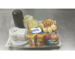 ein Tablett mit Speisen zum Frühstück und Getränken in der Unterkunft Motel Fantasy 1 in Belo Horizonte