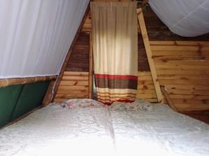 Hostal Colina de San Antonio في Jamundí: غرفة نوم صغيرة بسرير وستارة