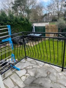 a iron fence with a table in a yard at Maison avec beau jardin in Pierrelaye