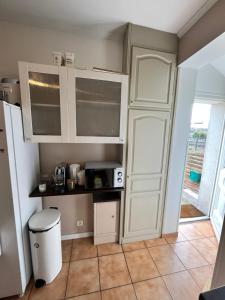 a kitchen with white cabinets and a door at Maison avec beau jardin in Pierrelaye