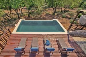 a swimming pool with lounge chairs on a deck at Greater Kruger View - Luxury Bush Villa in Marloth Park
