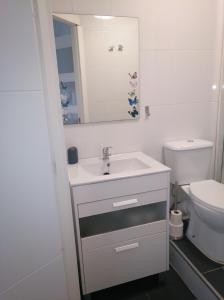 La salle de bains blanche est pourvue d'un lavabo et de toilettes. dans l'établissement Estudio. Sada, A Coruña., à Sada