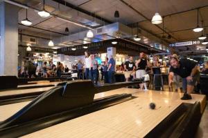 a group of people playing a game of bowling at CozySuites l Chic 1BR Bottleworks Indy #5 in Indianapolis