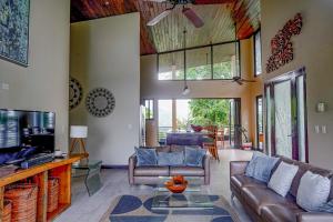 a living room with a couch and a tv at Casa Vista Verde in Uvita