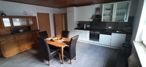 a kitchen with a wooden table and black chairs at Bacchus in Hatzenport