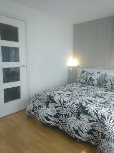 1 dormitorio con 1 cama con edredón blanco y negro en Estudio. Sada, A Coruña., en Sada