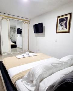 a white room with two beds and a mirror at Hermosa casa en Bucaramanga in Bucaramanga