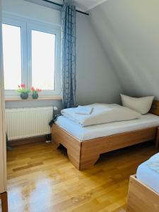 um quarto com 2 camas e 2 janelas em Ferienhaus Liese em Carolinensiel