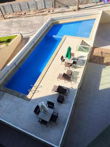 una vista aérea de una piscina con mesas y sillas en The Place Beach Aparts: desperte os melhores sentidos a beira-mar e ao lado do centro de convenções., en Salvador