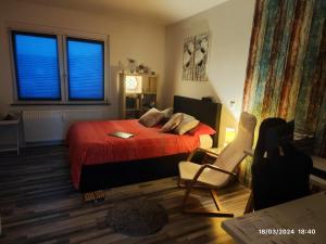 1 dormitorio con cama roja, silla y ventana en Airport Room en Düsseldorf