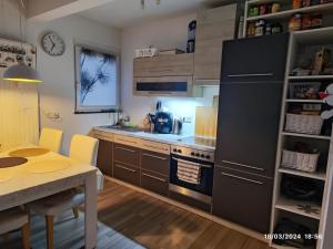 a kitchen with a table and a black refrigerator at Airport Room in Düsseldorf