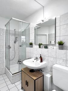 La salle de bains est pourvue d'un lavabo, d'une douche et de toilettes. dans l'établissement Sali - E1 - WLAN, Balkon, TV, à Essen