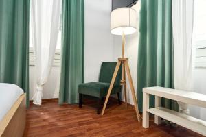 a room with a green chair and a lamp at Hotiday La Spezia Quiet Night in La Spezia +16 photos