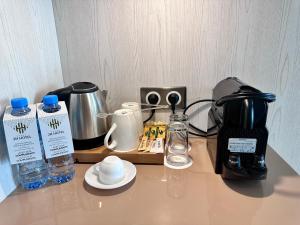 uma bancada com comodidades para preparar café e um liquidificador em 2H Hotel em Orã