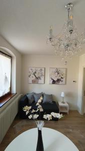 un soggiorno con divano e lampadario pendente di Sottocastello 1 a Gorizia