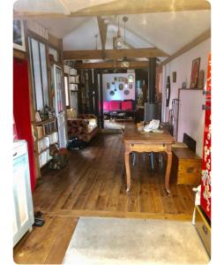 ein Wohnzimmer mit Holzboden und einem Tisch in der Unterkunft Maison avec terrasse-jardin proche métro in Montreuil